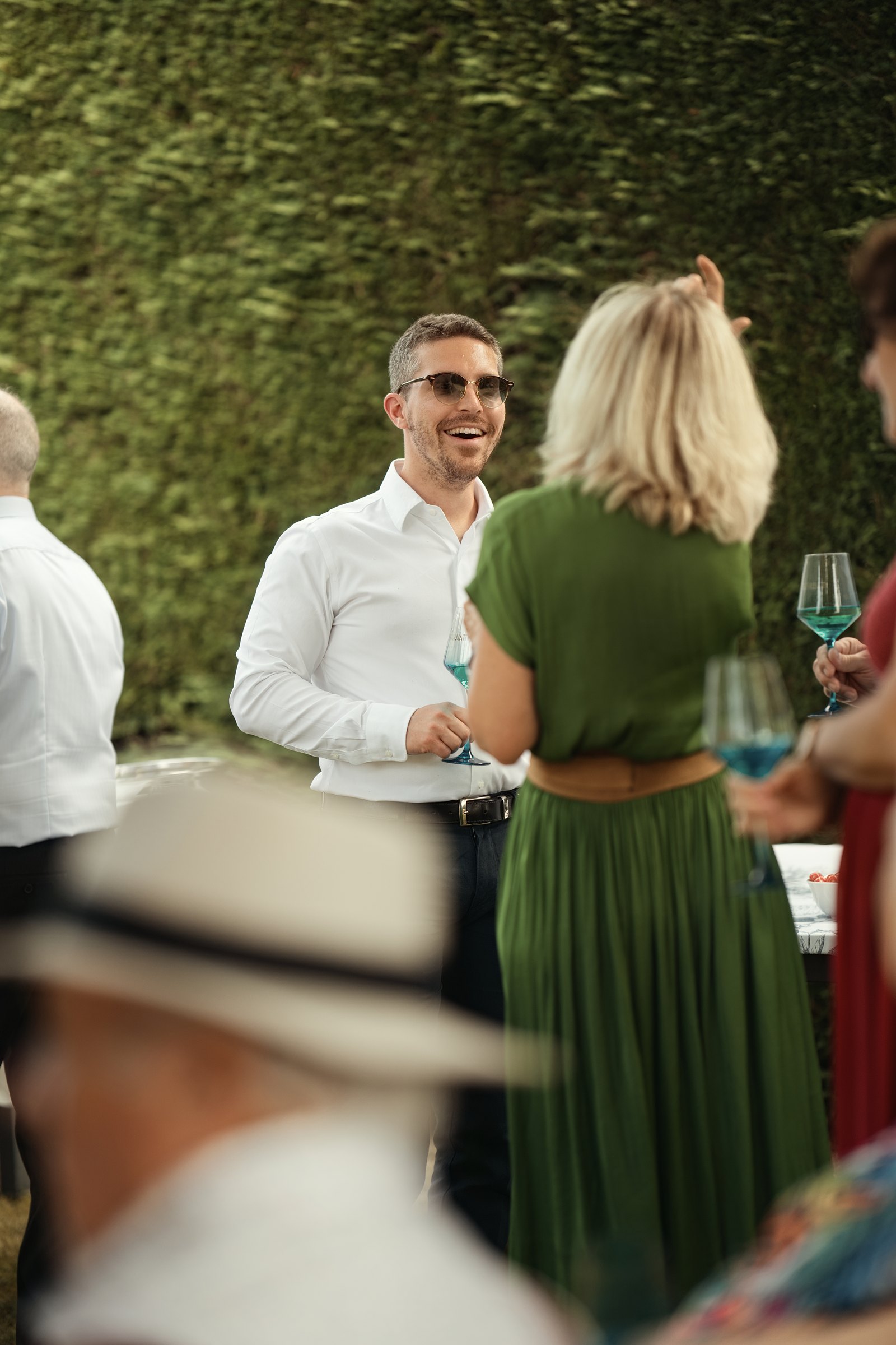 Un invité savoure un verre pendant la réception au jardin dans l’Eure