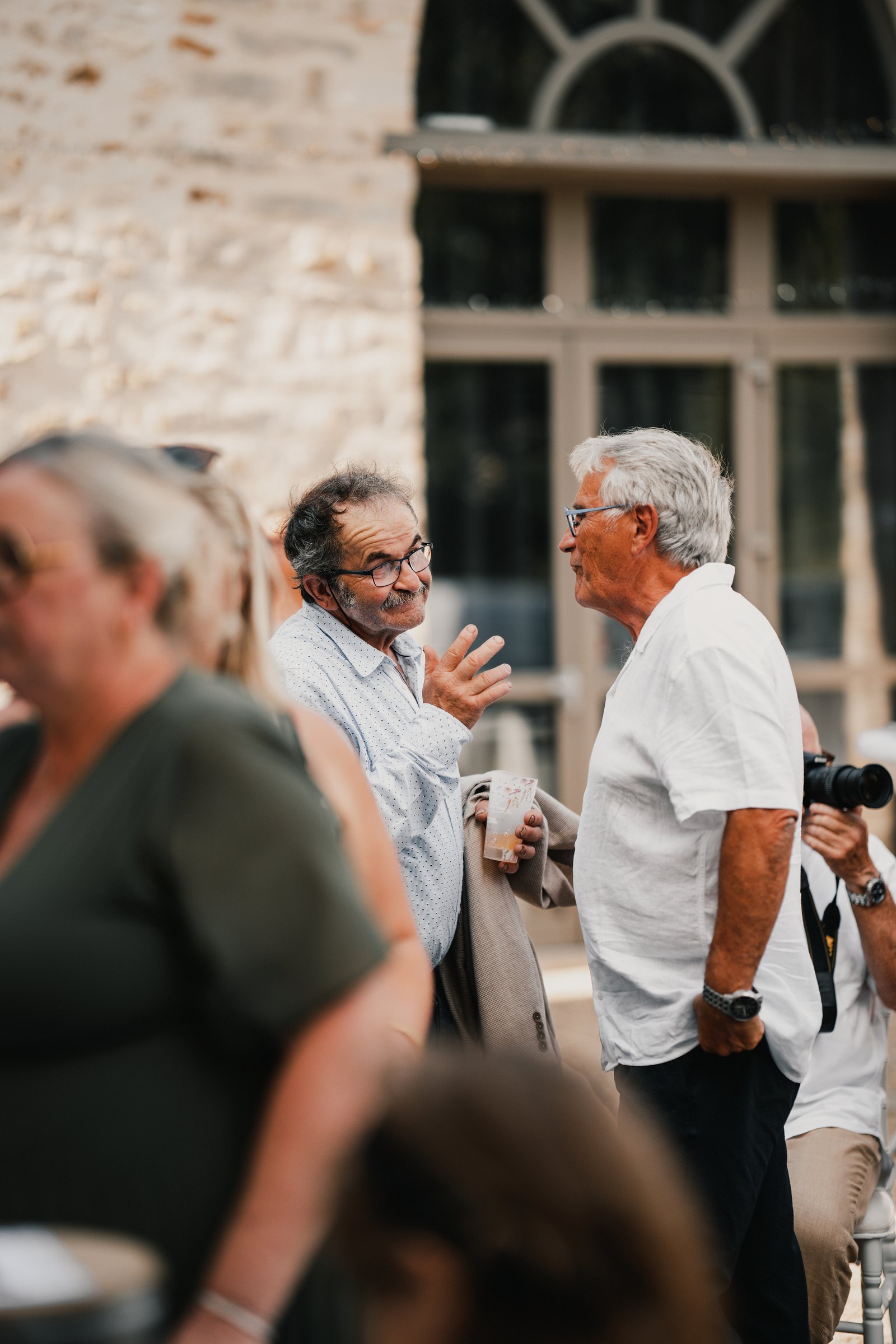 Deux invités discutent à l’écart dans la cour