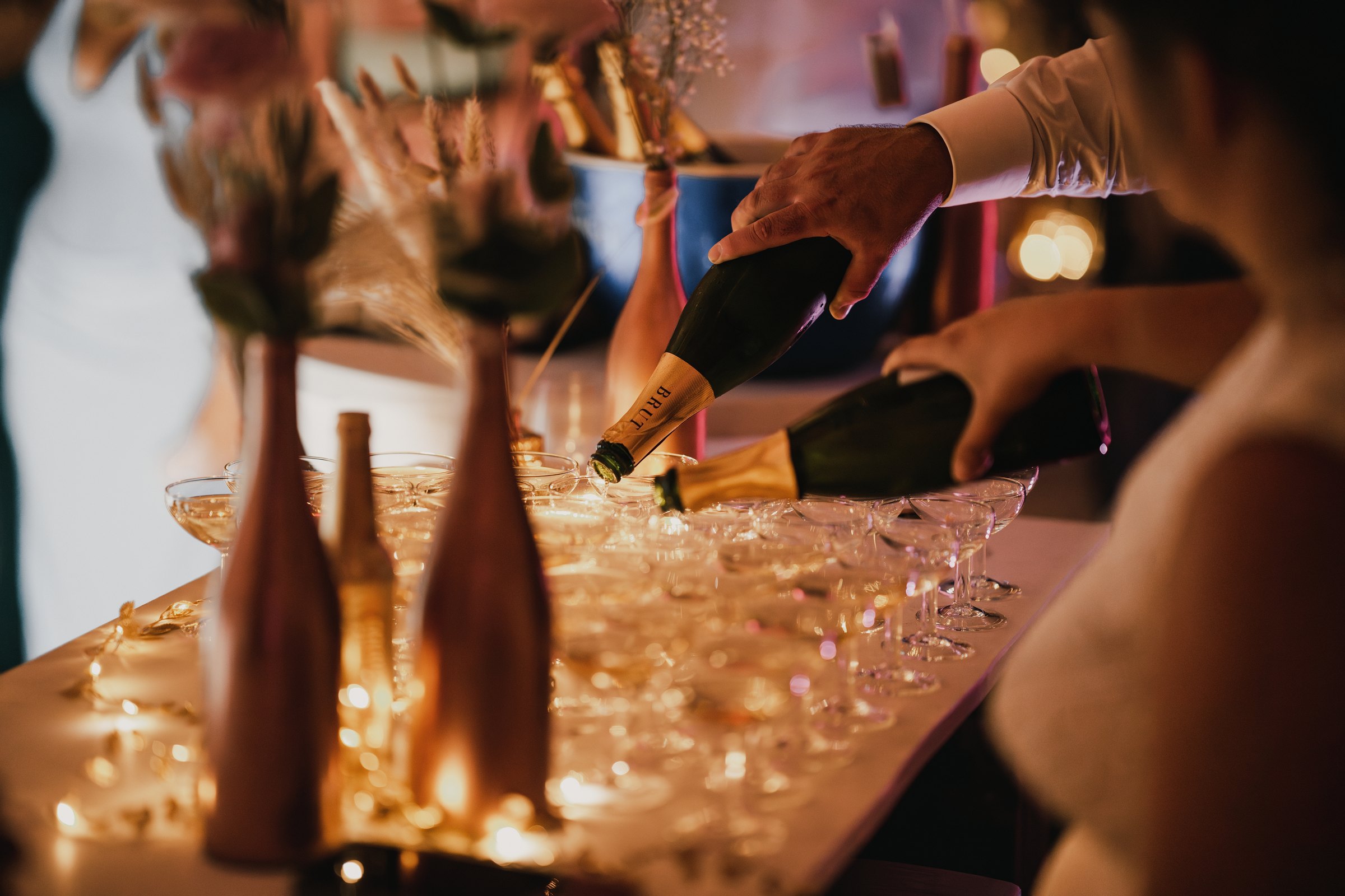 Le champagne coule dans les coupes sous les lumières de la soirée